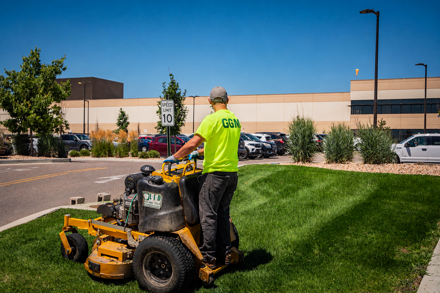 Commercial grounds maintenance crew mowing lawn at office complex